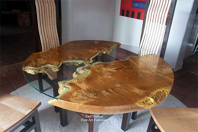 round live edge dining table at another angle showing highly-figured matched top made from red mulberry slabs and showing live edge through glass
